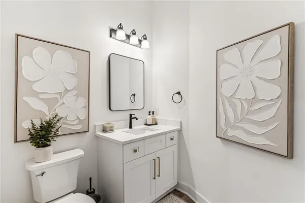 a bathroom with a granite countertop sink a toilet and a shower