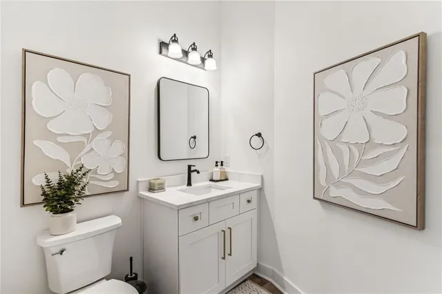 a bathroom with a granite countertop sink a toilet and a shower