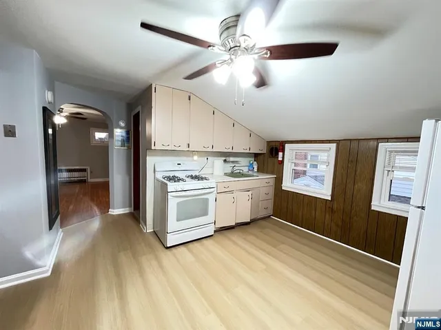 a view of a kitchen with stainless steel appliances a sink and a refrigerator