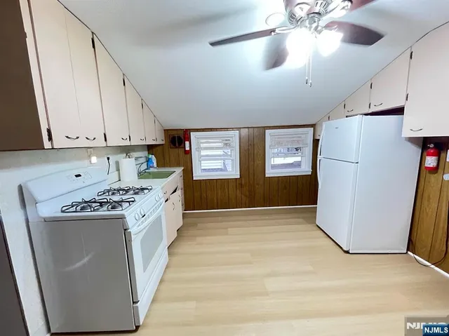 a kitchen with a refrigerator a stove top oven a sink and dishwasher