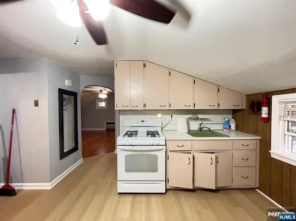 a kitchen with a white stove top oven and cabinets