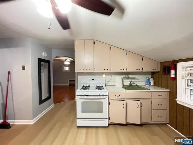 a kitchen with a white stove top oven and cabinets