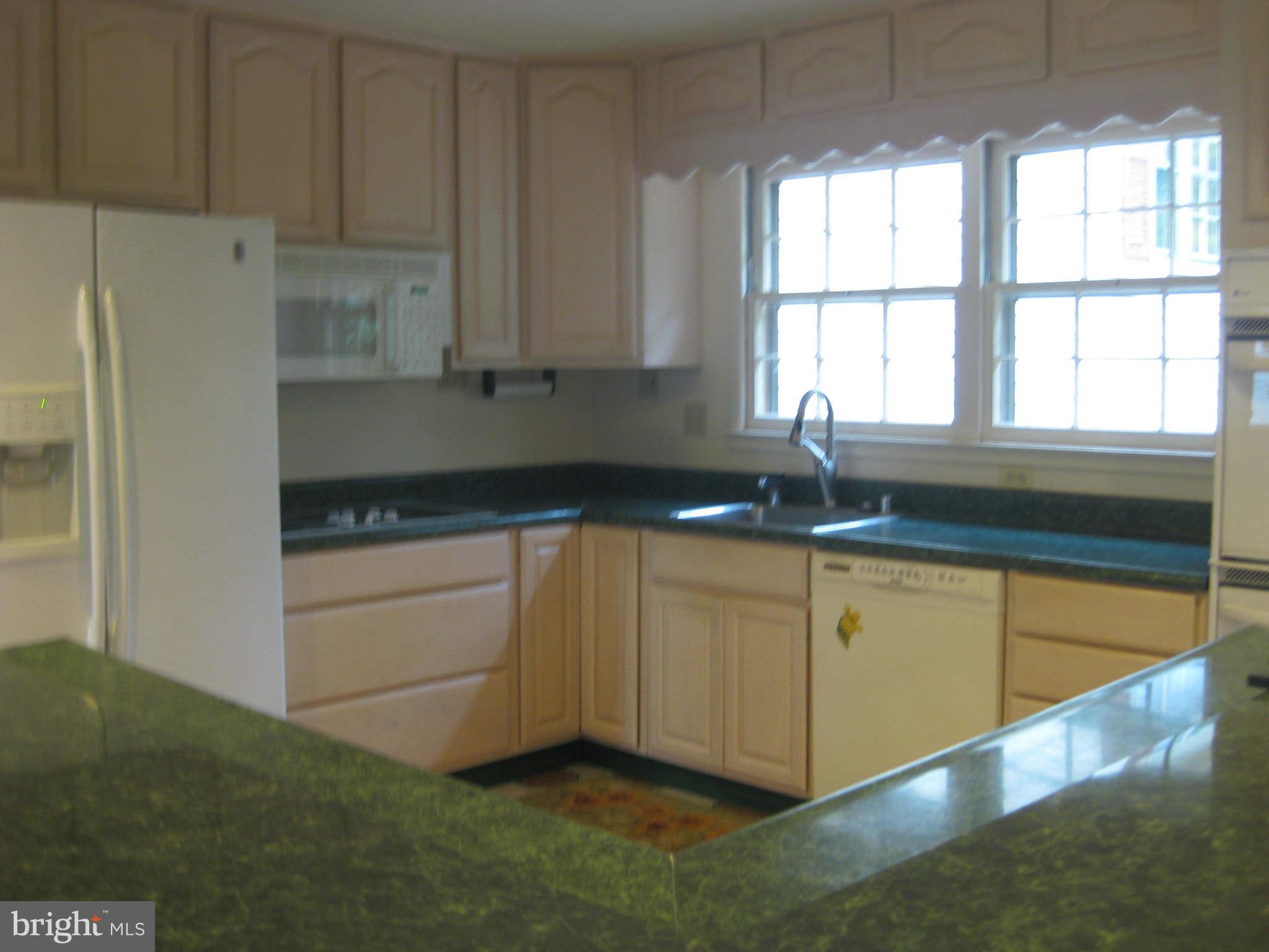 6405 Meriwether Lane Springfield, VA 22150 - Photo 4 of 14 a kitchen with granite countertop a sink and a white cabinets