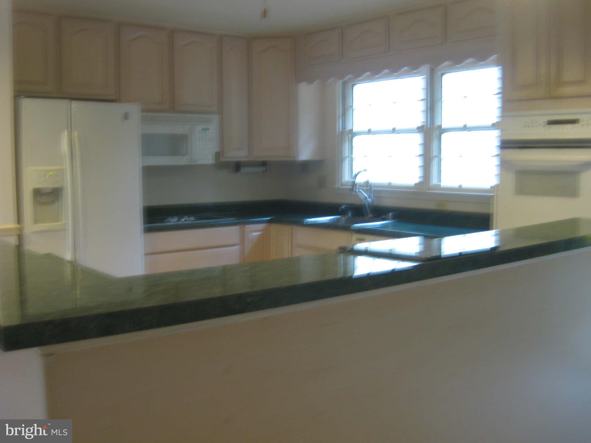 6405 Meriwether Lane Springfield, VA 22150 - Photo 5 of 14 a kitchen with granite countertop white cabinets and a large window