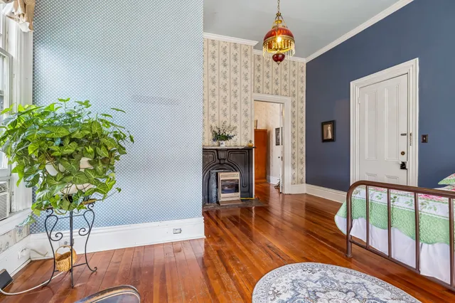 a bedroom with a bed and wooden floor