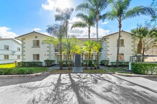 a front view of multi story residential apartment building with yard and green space