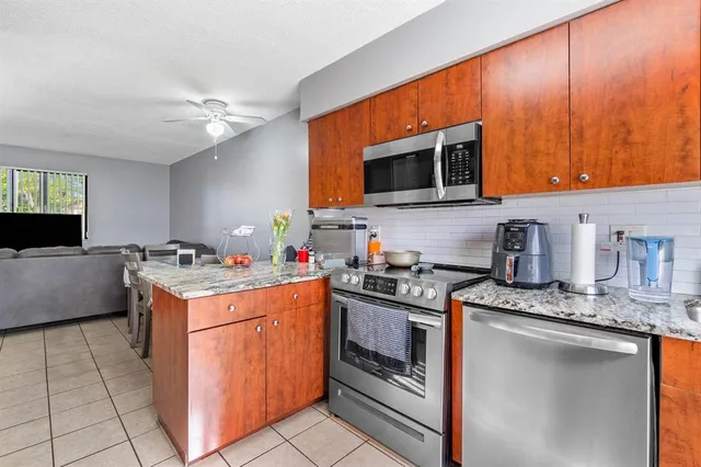 a kitchen with stainless steel appliances granite countertop a sink a stove and a refrigerator