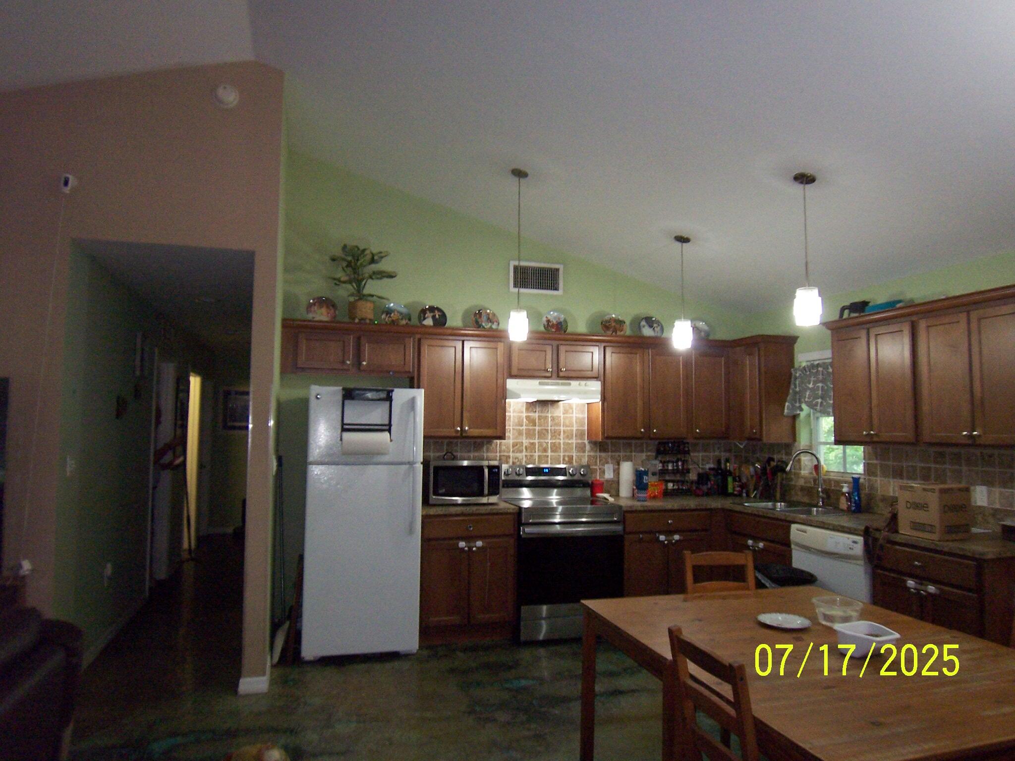 Undisclosed Address Key Largo, FL 33037 - Photo 6 of 19 a kitchen with stainless steel appliances granite countertop a refrigerator a stove and a sink with wooden floor