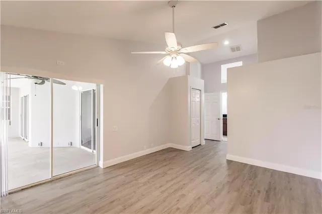 an empty room with wooden floor and windows