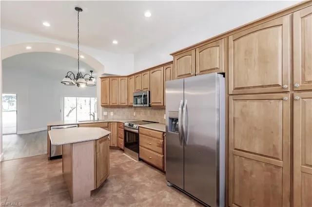 a kitchen with refrigerator a sink and cabinets