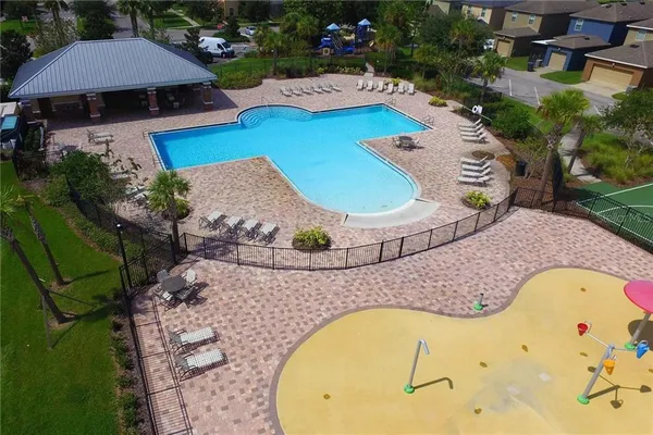 an aerial view of a house with swimming pool and outdoor seating