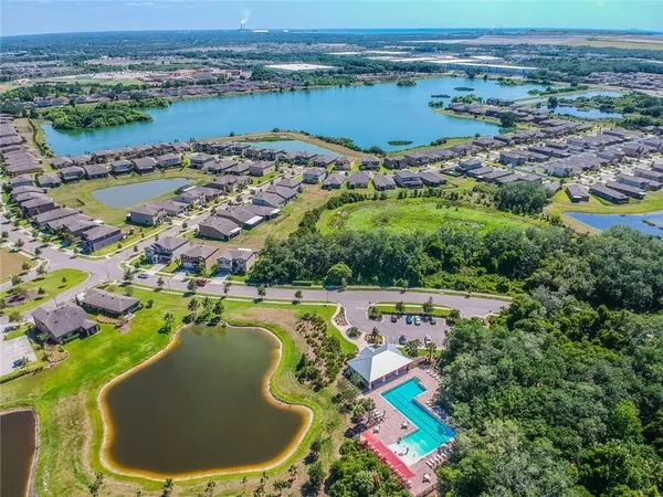 an aerial view of a house with outdoor space and a lake view in back