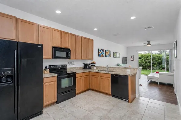 a large kitchen with stainless steel appliances granite countertop a stove sink and cabinets