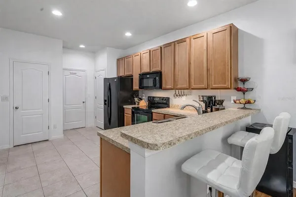 a large kitchen with granite countertop a large counter top stainless steel appliances and cabinets