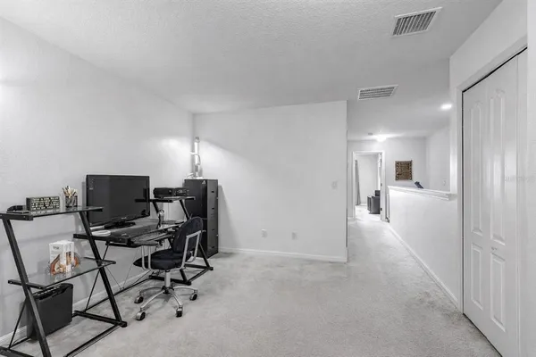 a view of a workspace with furniture and a window