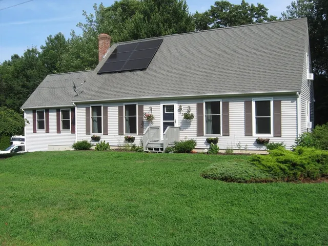 a house that is sitting in a big yard with large trees