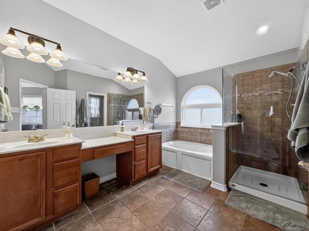 2679 Lake Ridge Drive Little Elm, TX 75068 - Photo 22 of 40 Bathroom with double vanity, a stall shower, a garden tub, and vaulted ceiling