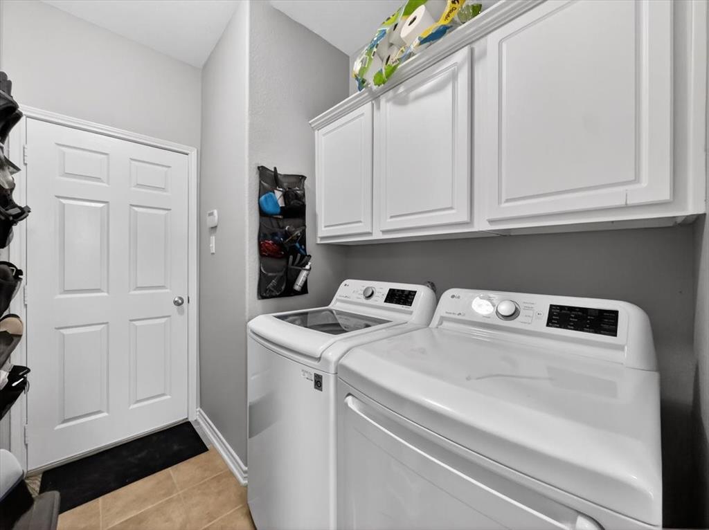 2679 Lake Ridge Drive Little Elm, TX 75068 - Photo 34 of 40 Laundry area with washer and dryer, light tile patterned flooring, and cabinet space
