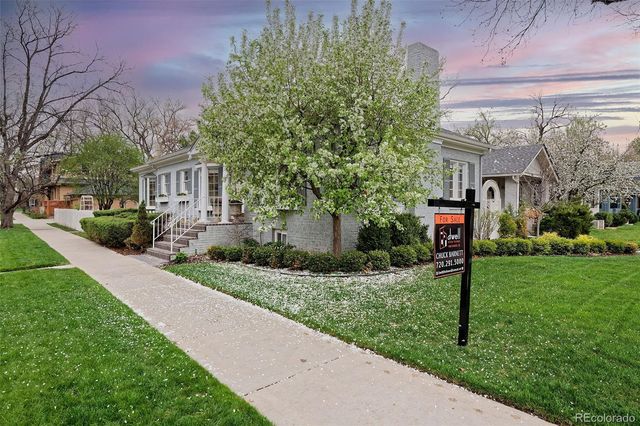 a front view of a house with a yard and a garden