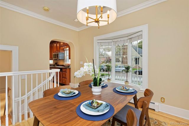 a view of a dining room with furniture a chandelier and wooden floor