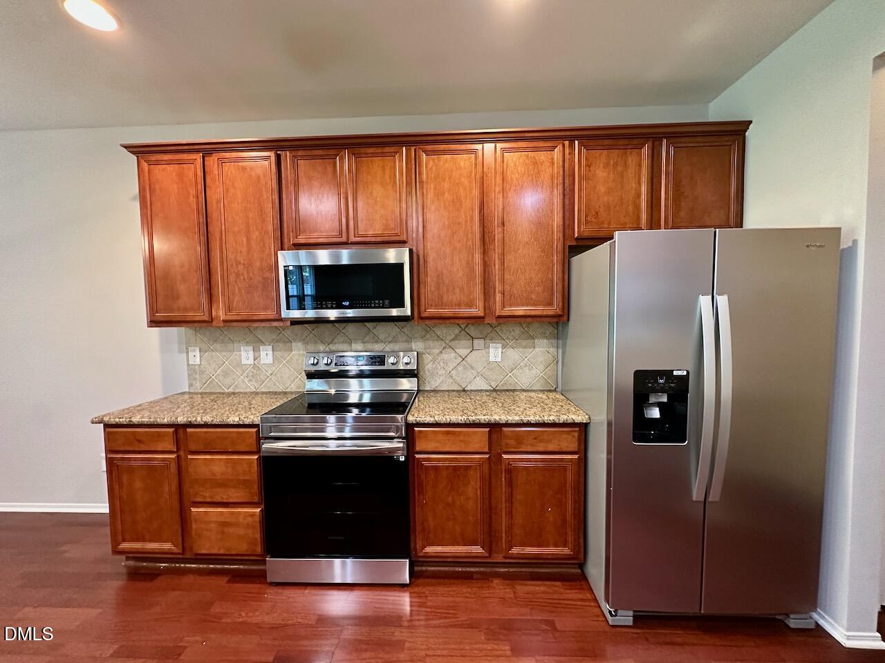 8208 Stone Cellar Drive Raleigh, NC 27613 - Photo 14 of 34 a kitchen with stainless steel appliances granite countertop a refrigerator and a stove top oven