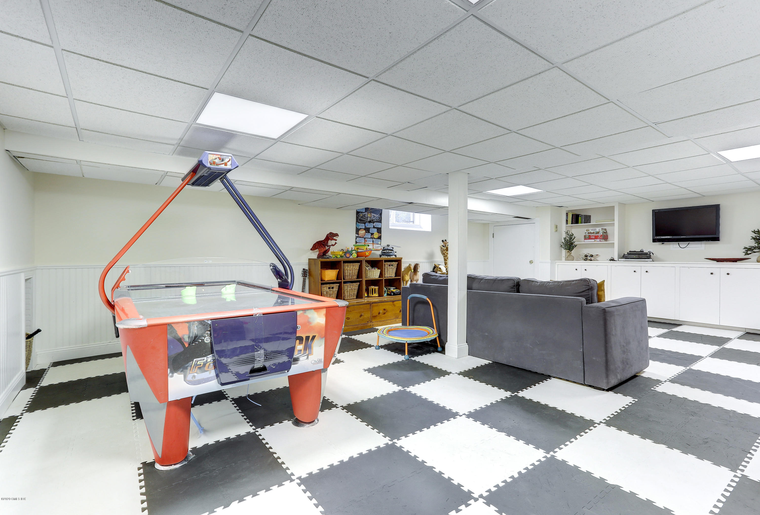 10 Indian Chase Drive Greenwich, CT 06830 - Photo 16 of 27 a room with furniture a flat screen tv and a chandelier