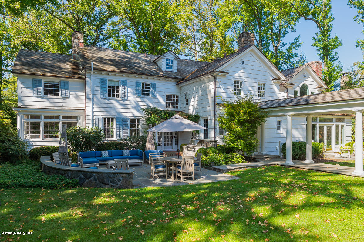 10 Indian Chase Drive Greenwich, CT 06830 - Photo 17 of 27 a front view of a house with a yard table and chairs