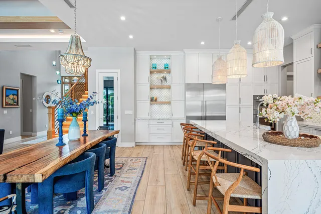 a dining room filled chandelier and kitchen view