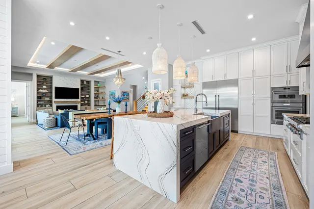 a large kitchen with stainless steel appliances kitchen island granite countertop a large counter top and wooden floors