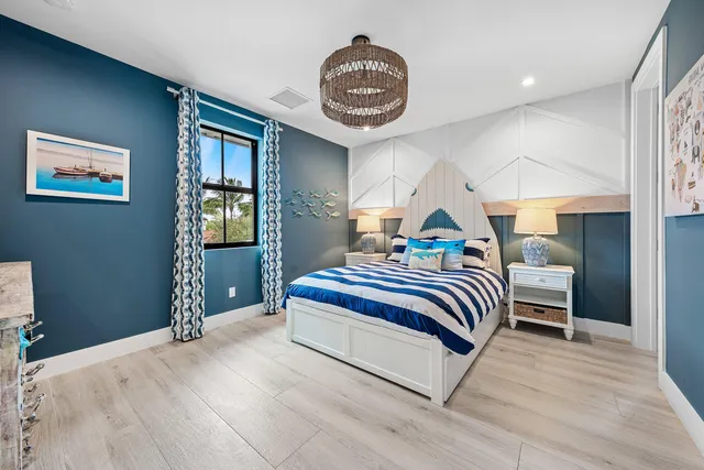 a spacious bedroom with a bed and a chandelier