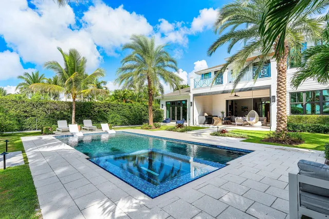 a view of a house with swimming pool and sitting area
