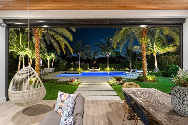 an aerial view of a houses with a yard and lake view in back