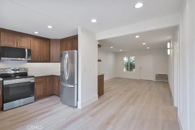 a view of kitchen with stainless steel appliances granite countertop a refrigerator and a stove top oven