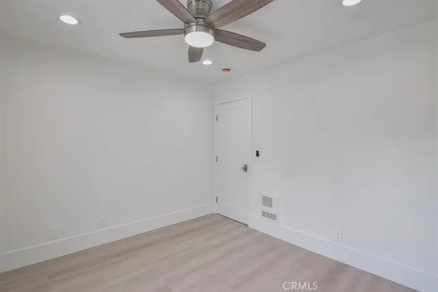 an empty room with fan and entrance