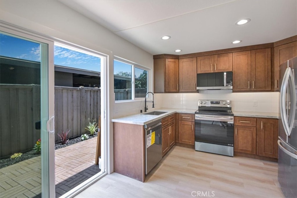 229 Springview Irvine, CA 92620 - Photo 3 of 30 a kitchen with stainless steel appliances granite countertop a stove a refrigerator and a sink