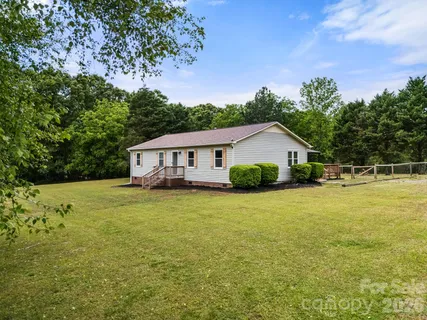 a front view of house with yard and trees in the background