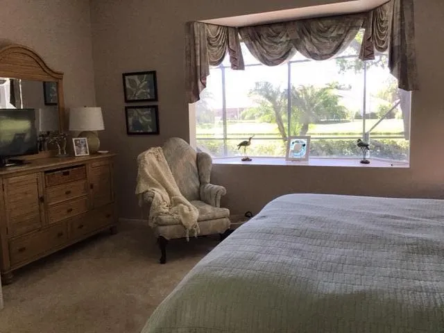 a bedroom with a bed chair and window