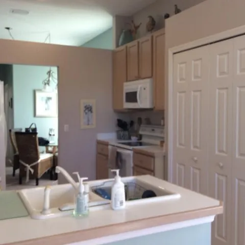 a kitchen with a refrigerator sink and wooden floor