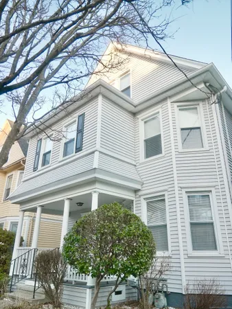 a front view of a house with a tree