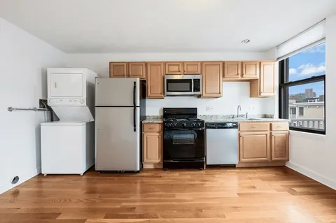 a kitchen with a refrigerator a stove top oven a sink and cabinets