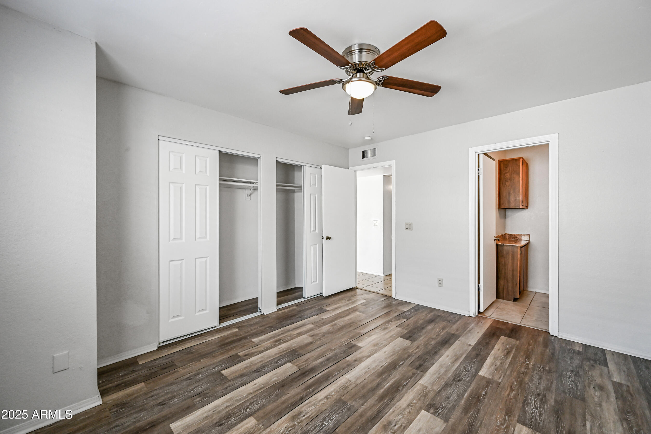 5580 South Kings Ranch Road, Unit 1 Gold Canyon, AZ 85118 - Photo 13 of 19 an empty room with wooden floor and a ceiling fan