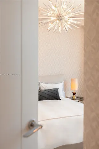 a bedroom with a bed and a lamp with the wall