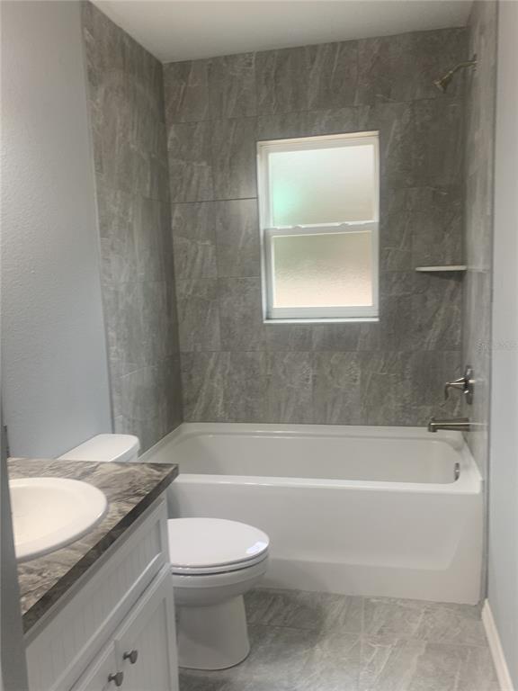 16201 Crider Road Brooksville, FL 34614 - Photo 14 of 18 a bathroom with a granite countertop toilet a sink and bathtub