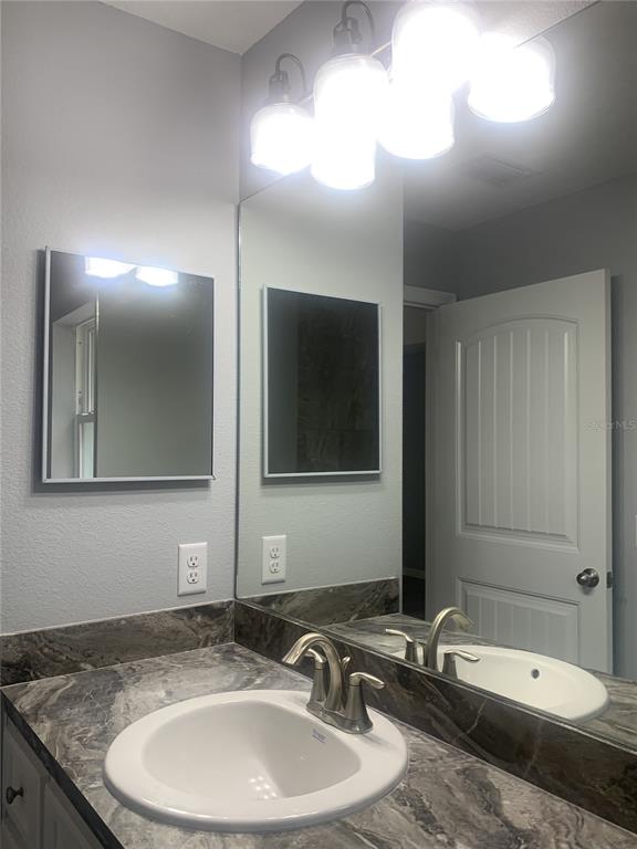 16201 Crider Road Brooksville, FL 34614 - Photo 15 of 18 a bathroom with a granite countertop sink and mirror