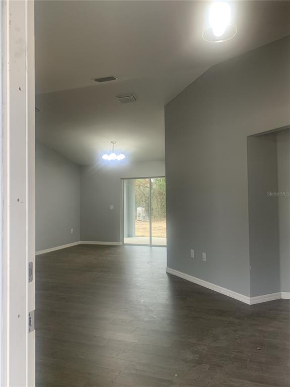 16201 Crider Road Brooksville, FL 34614 - Photo 2 of 18 an empty room with wooden floor and windows