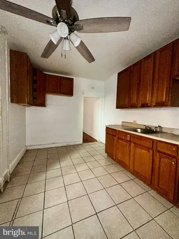 a kitchen with a sink a stove cabinets and utility room