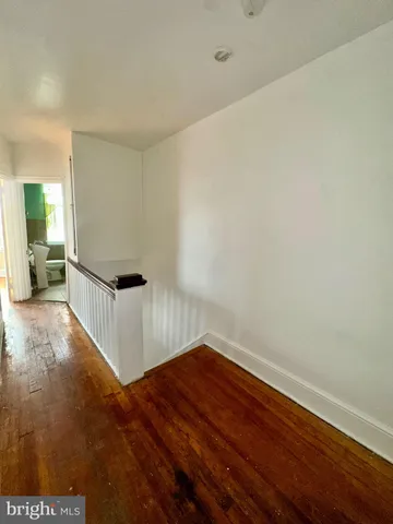 a view of hallway with stairs and wooden floor