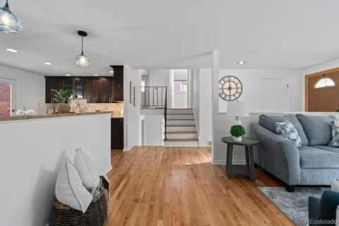 a living room with stainless steel appliances kitchen island granite countertop furniture a rug kitchen view and a chandelier