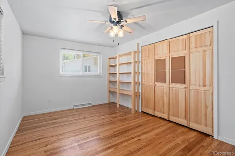 a view of an empty room with a window and wooden floor
