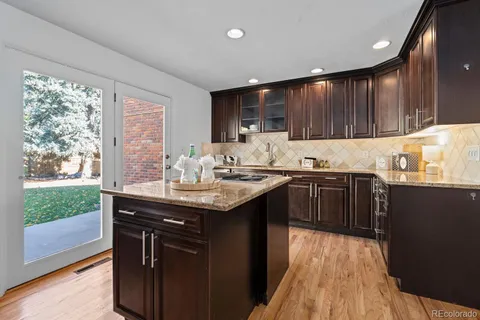 a kitchen with kitchen island granite countertop a sink appliances and cabinets